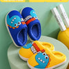 A display of blue and yellow cartoon dinosaur plush slippers on a light green surface.