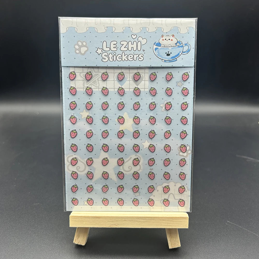 A vertical sheet of light blue decorative stickers featuring cute animals and fruit for crafting