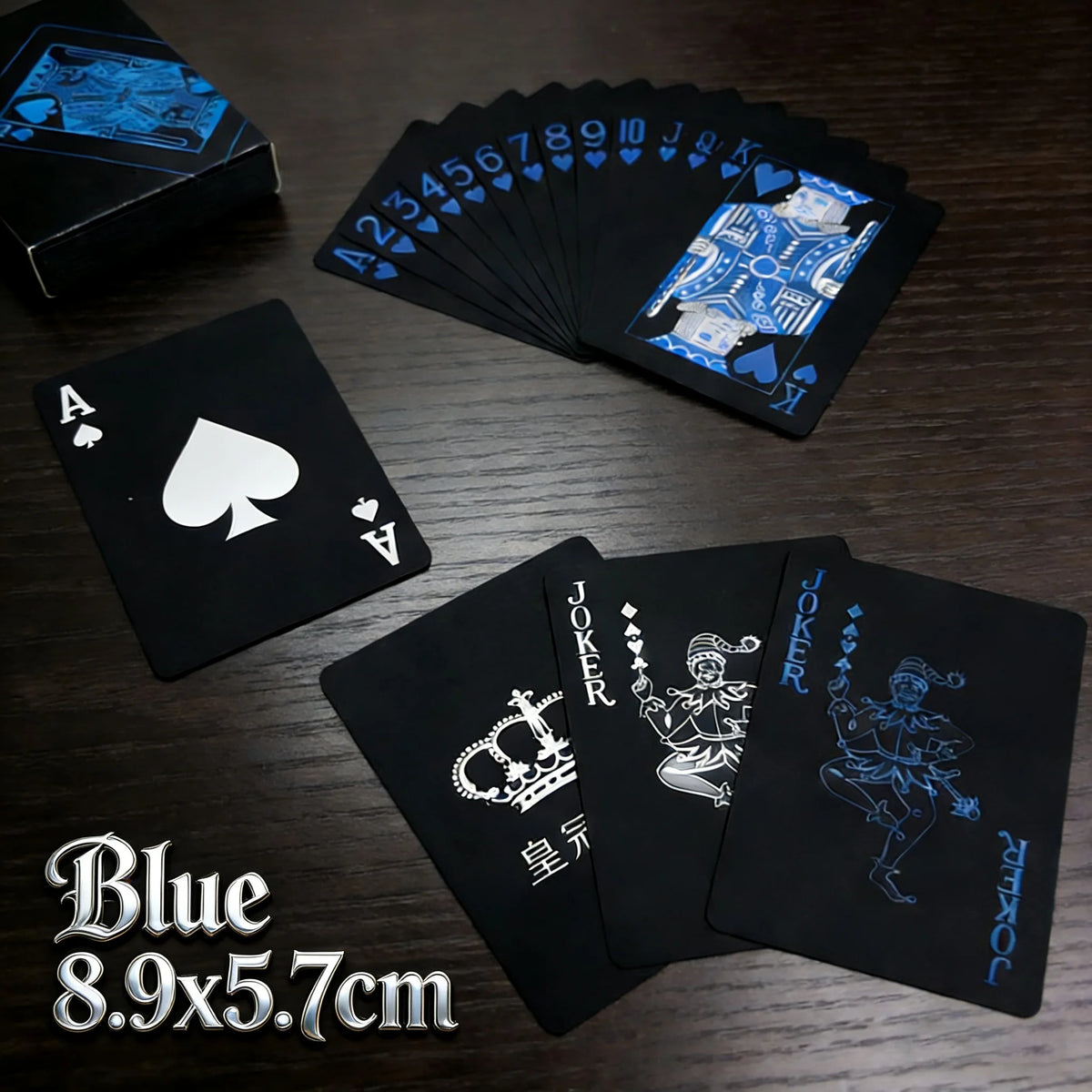 A stack of blue playing cards and a single black card are displayed on a wooden surface.