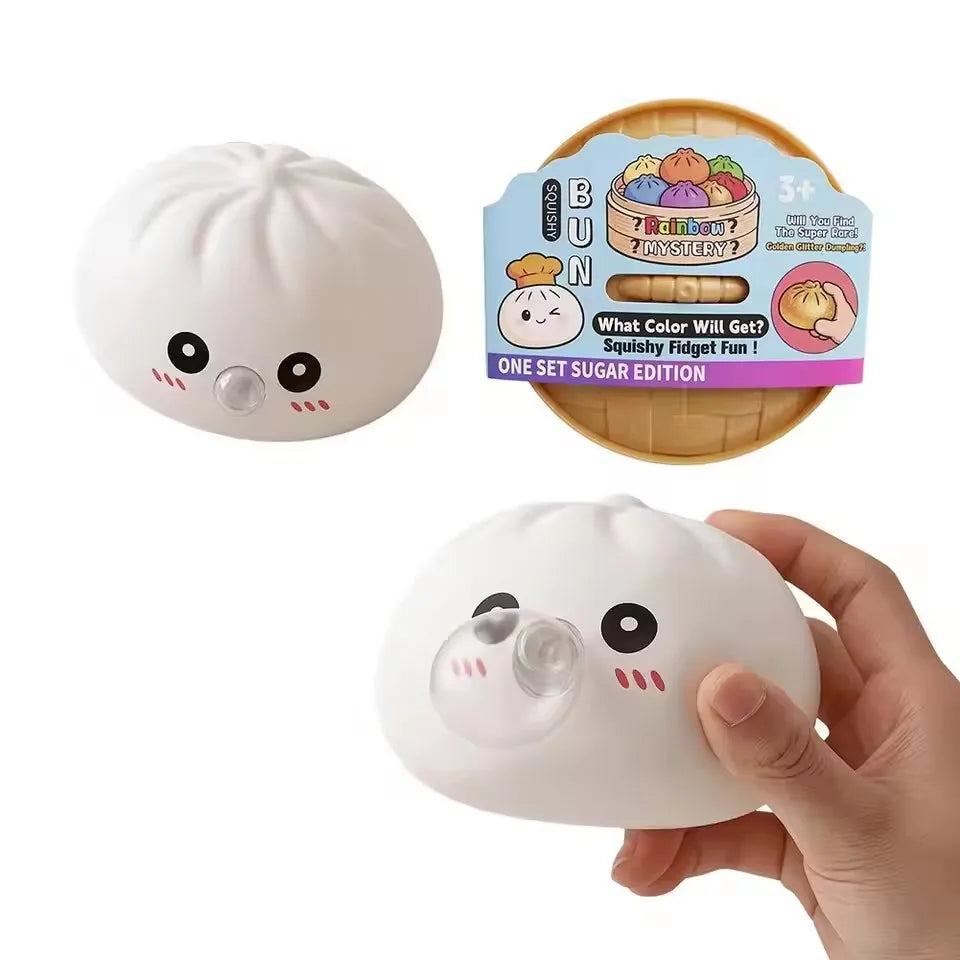 A white squishy dumpling stress relief toy is shown in a hand, next to its packaging.