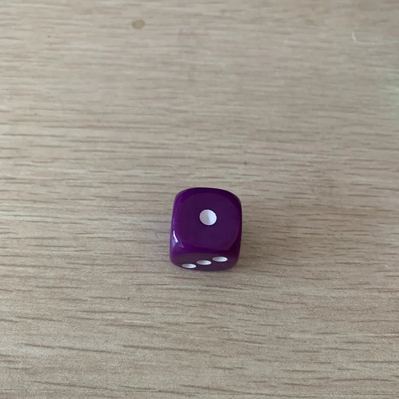 A single purple acrylic die with a white pips on a light wooden surface.