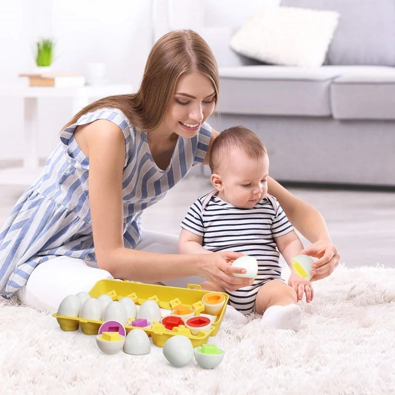 Une femme aide un bébé à assortir des pièces de puzzle en forme d'œuf de différentes couleurs sur un tapis blanc.