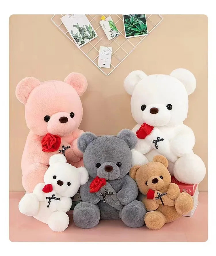 A collection of plush bears in pink, white, and gray colors with rose accents displayed on a light background.