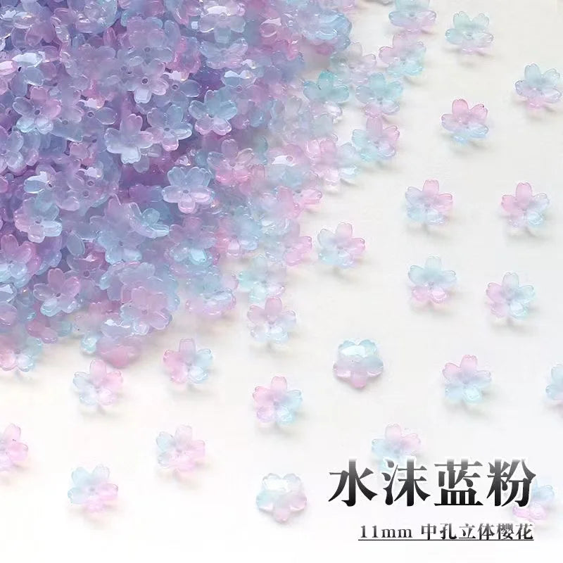 A pile of iridescent purple and blue sakura flower crystal glass beads for jewelry making.