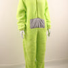 A person wearing a lime green fuzzy one-piece pajama costume with a gray chest patch.