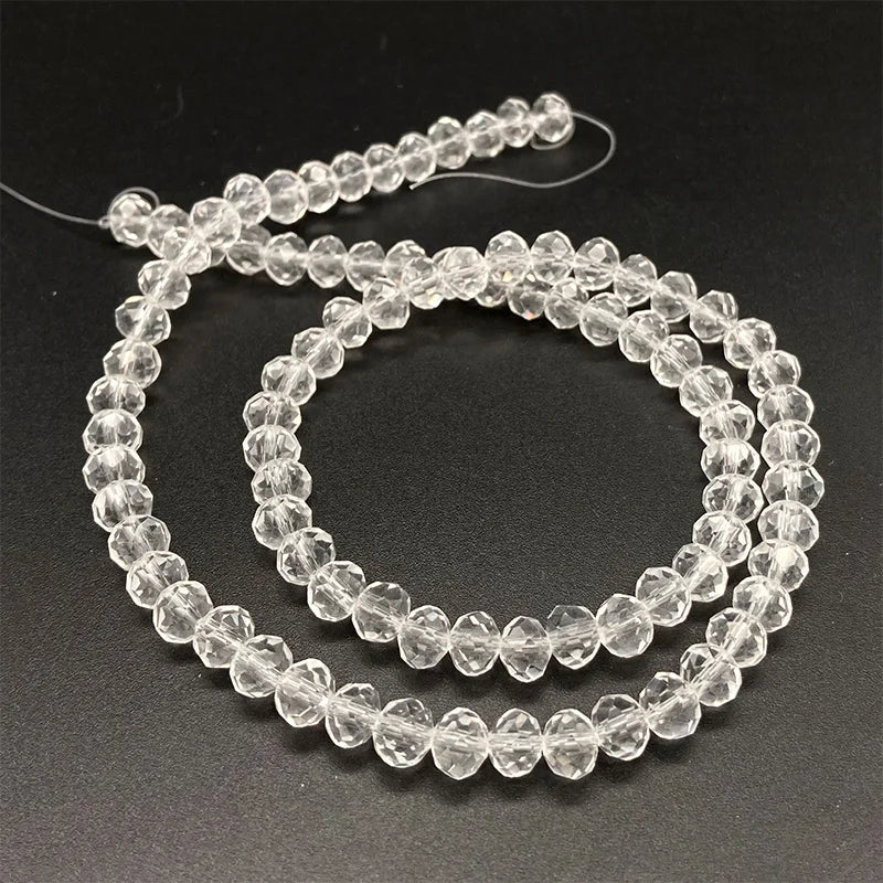 A string of clear, faceted crystal beads used for jewelry making.