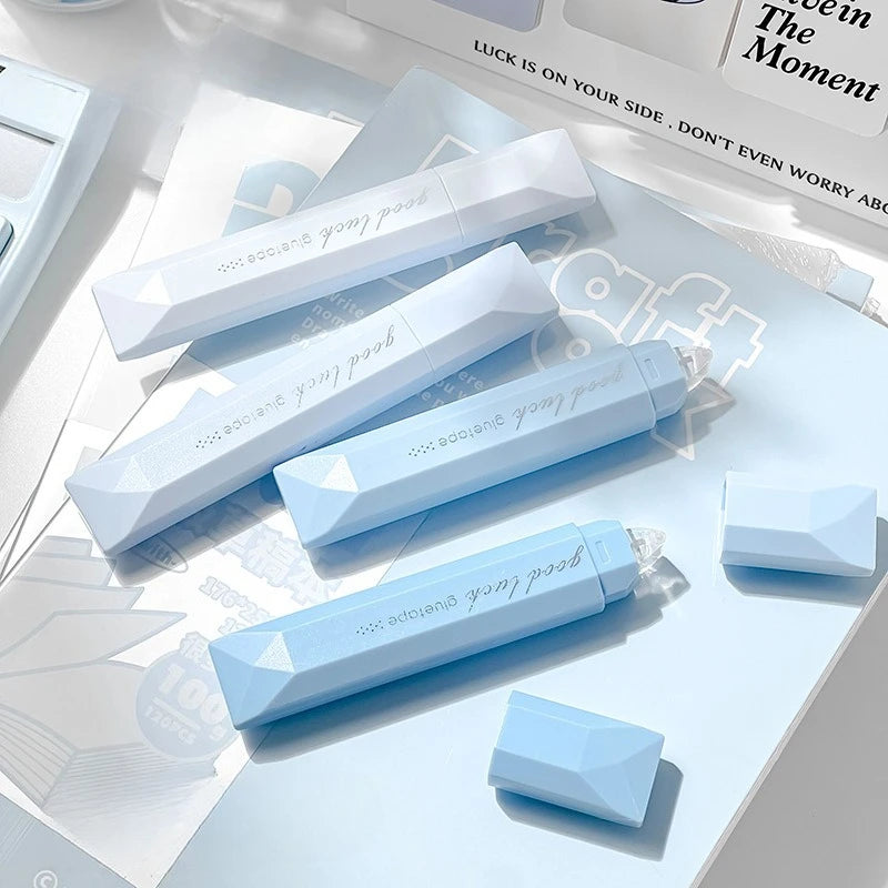 A close-up of four light blue adhesive dot tape glue rollers arranged on a white background.