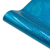 Close-up of a glossy, iridescent blue glitter heat transfer vinyl sheet rolled into a cylinder.