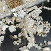A collection of white and gold acrylic pearl beads for jewelry making, including various shapes like flowers, butterflies, an