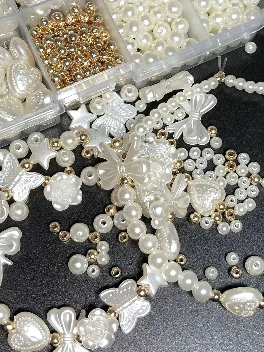 A collection of white and gold acrylic pearl beads for jewelry making, including various shapes like flowers, butterflies, an
