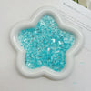 A white heart-shaped mold filled with sparkling blue ice strips for nail art and DIY crafts