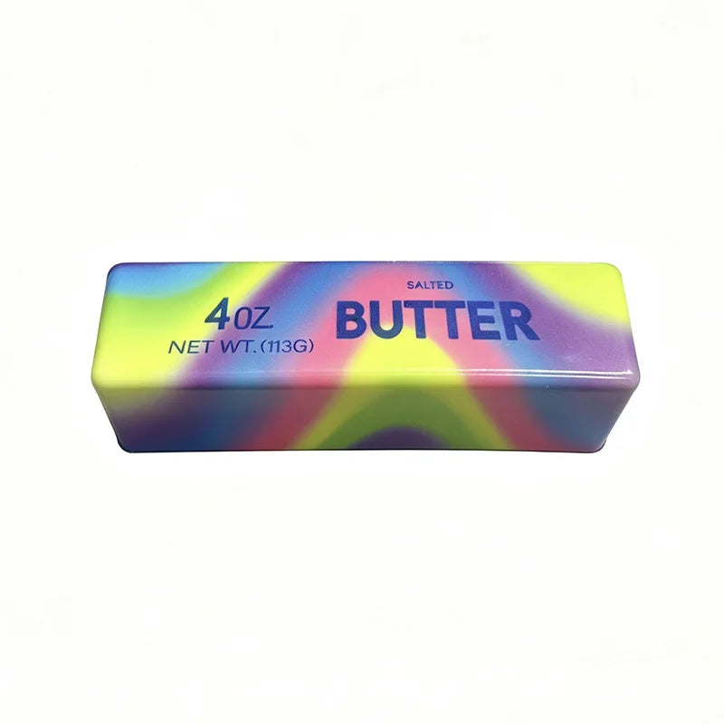 Rechteckiges lila und gelbes Quetschspielzeug mit der Aufschrift 'gesalzene Butter 4 oz Netto 113g'