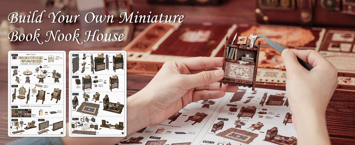Hands assemble a miniature book nook kit featuring detailed furniture and decorative elements on a wooden surface.