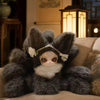 A fluffy gray fox plush collectible with white accents is displayed on a wooden surface.
