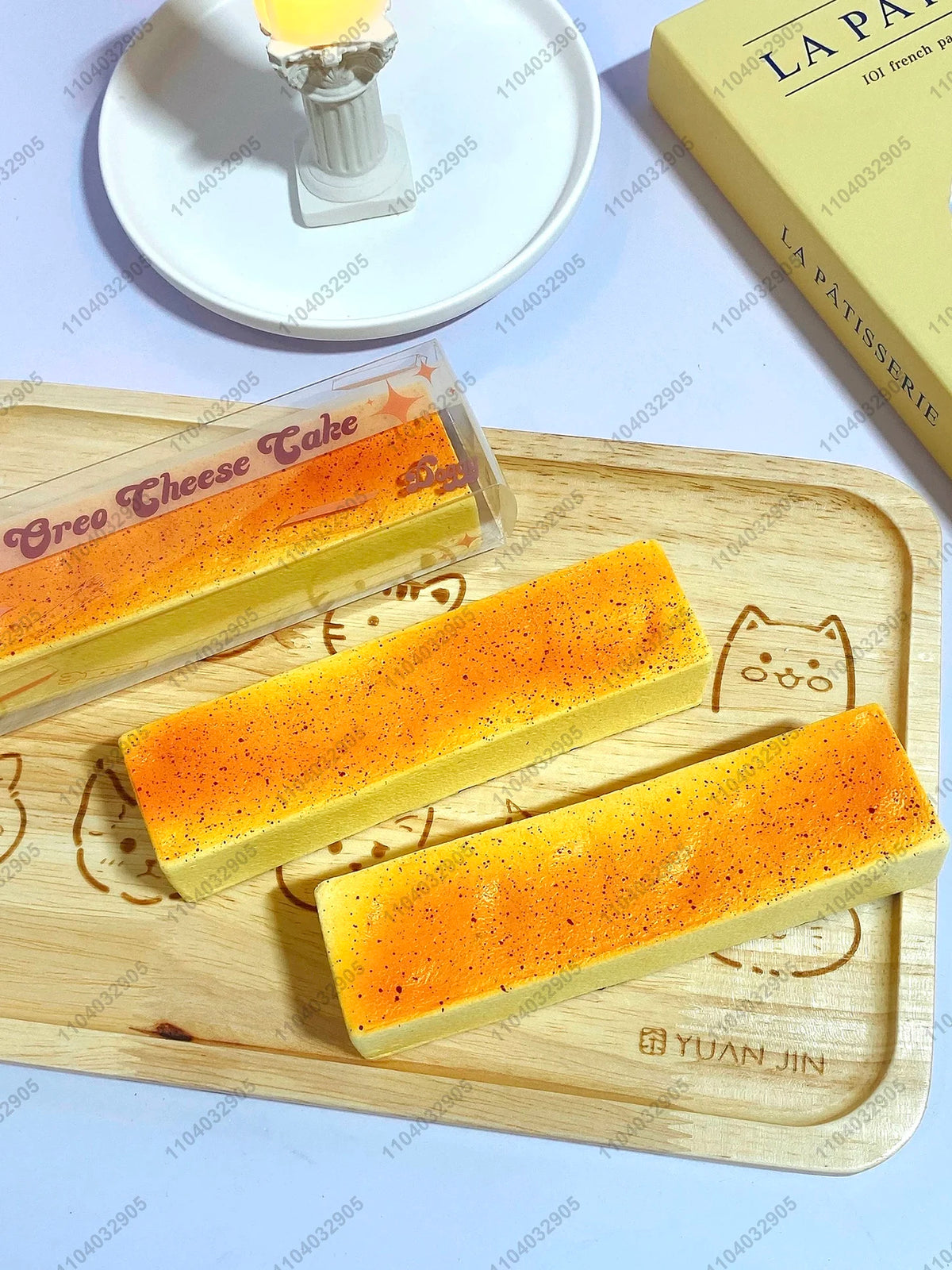 A rectangular orange butter stick squishy toy is displayed on a wooden cutting board.