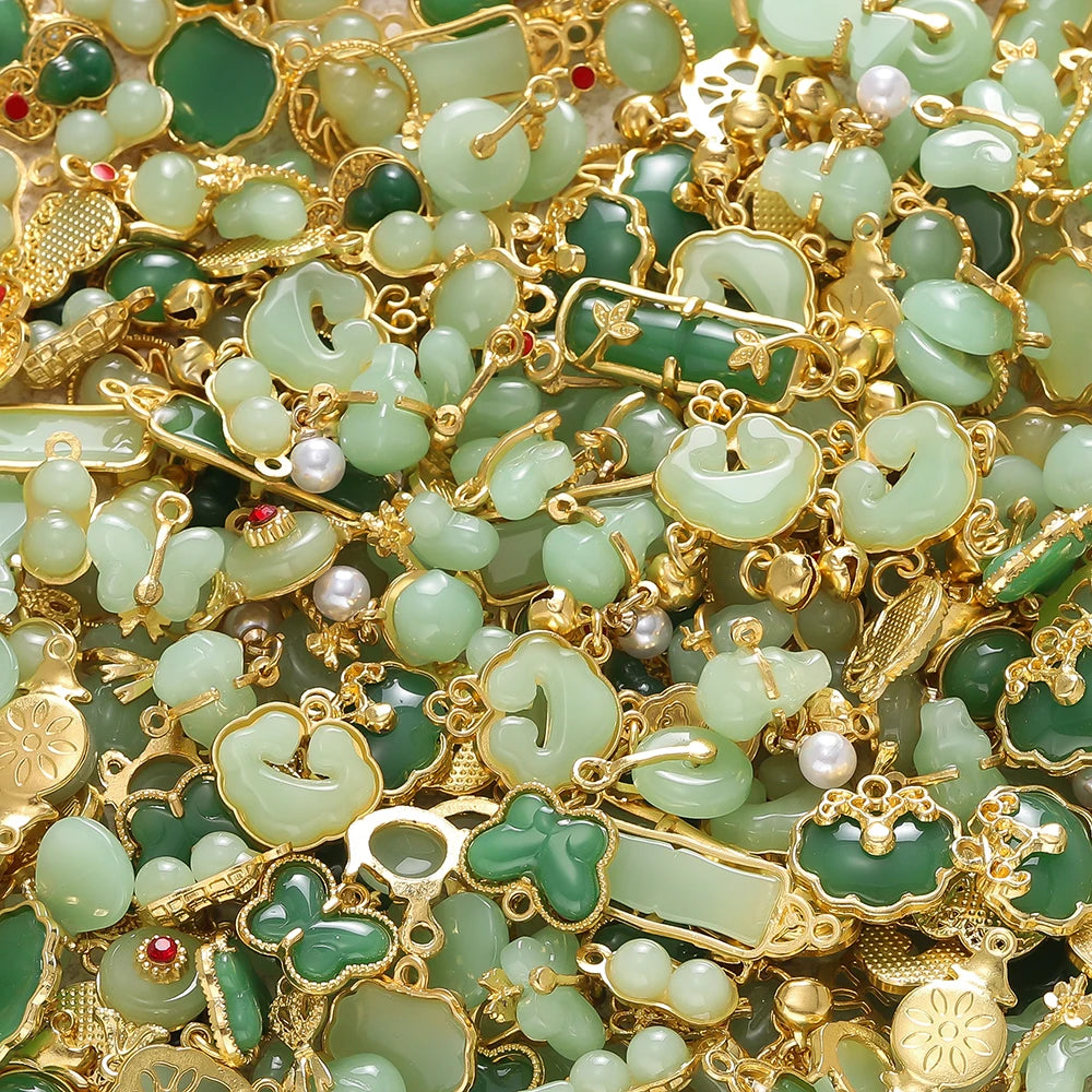 Close-up of small green imitation jade charms and beads set in gold-toned jewelry findings.