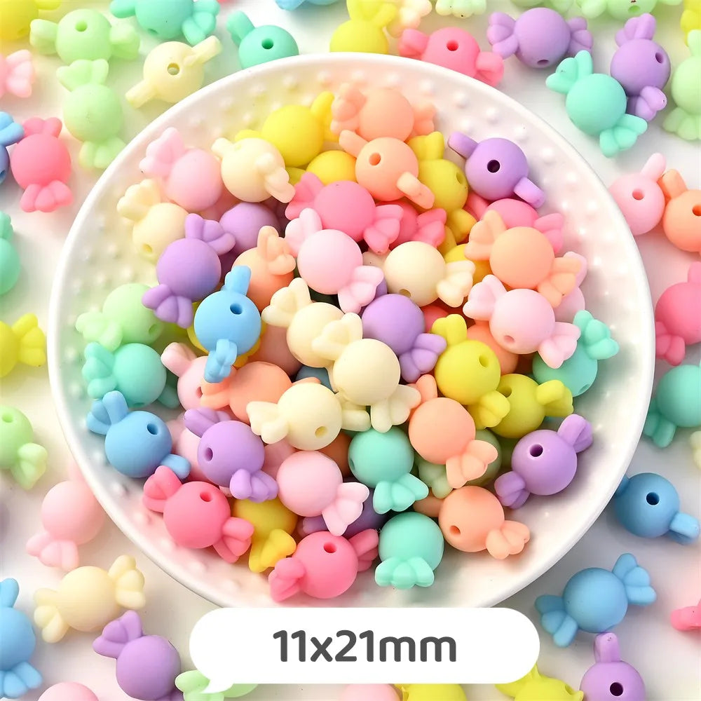A bowl filled with pastel bear-shaped acrylic craft beads in various shades of pink, yellow, purple, and blue.
