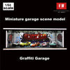 A miniature garage scene model featuring graffiti, cars, and a display within an acrylic showcase.