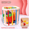 A light red plastic toy box containing four colorful fruits for a shape-sorting educational play set