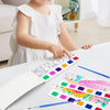 A child is painting with a portable watercolor book featuring colorful illustrations and paintbrushes.