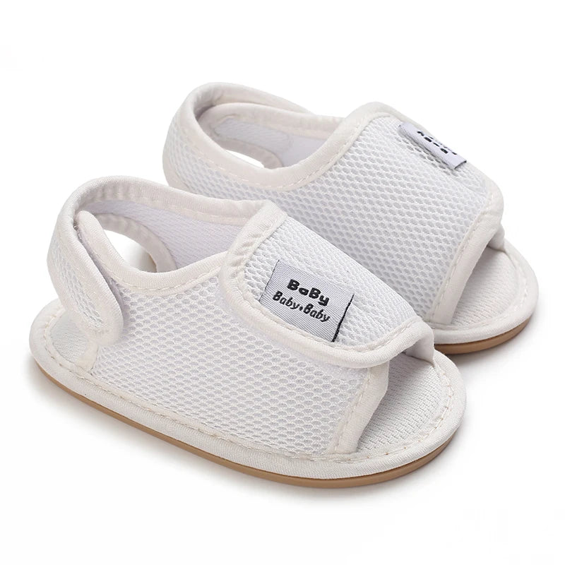 A pair of white breathable baby first walker sandals with a soft anti-slip sole shown from the top and side.