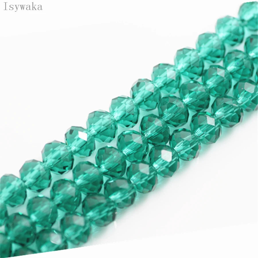 A close-up of green crystal glass beads used for jewelry making, arranged in a linear strand.