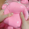 Eine Hand drückt einen großen, pinken, weichen Stressball-Fidget-Spielzeug in klarem Plastik verpackt.