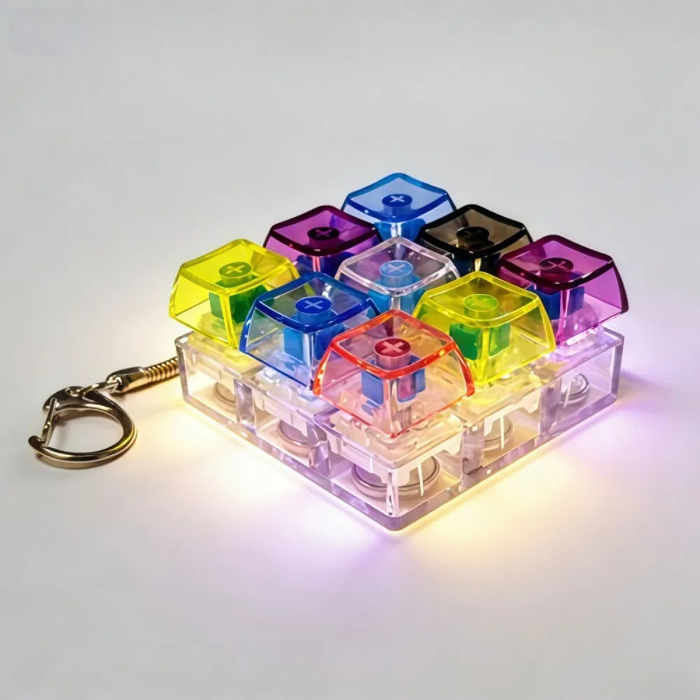 A collection of colorful LED light-up keycaps arranged in a plastic tray, attached to a metal keychain.