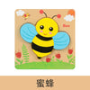 A wooden puzzle featuring a yellow bee with blue wings and black stripes, set in a grassy outdoor scene.