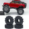 Un camion RC crawler rouge avec des roues et pneus en caoutchouc souple, présenté sur un fond blanc.