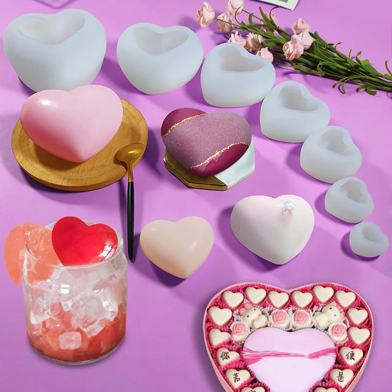 A collection of white and pink silicone heart molds for DIY crafts, including various sizes and a glass of pink liquid.