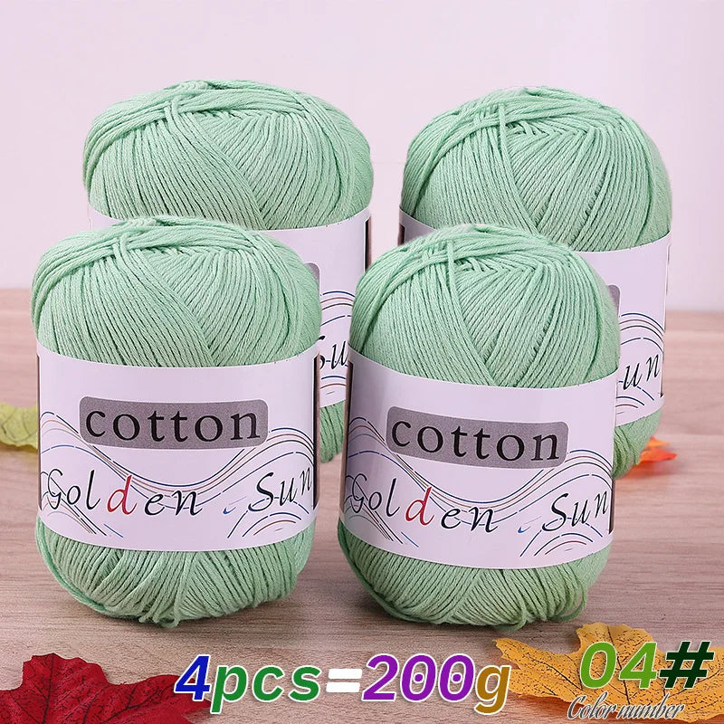 Four skeins of light green cotton knitting yarn for crochet and handmade projects