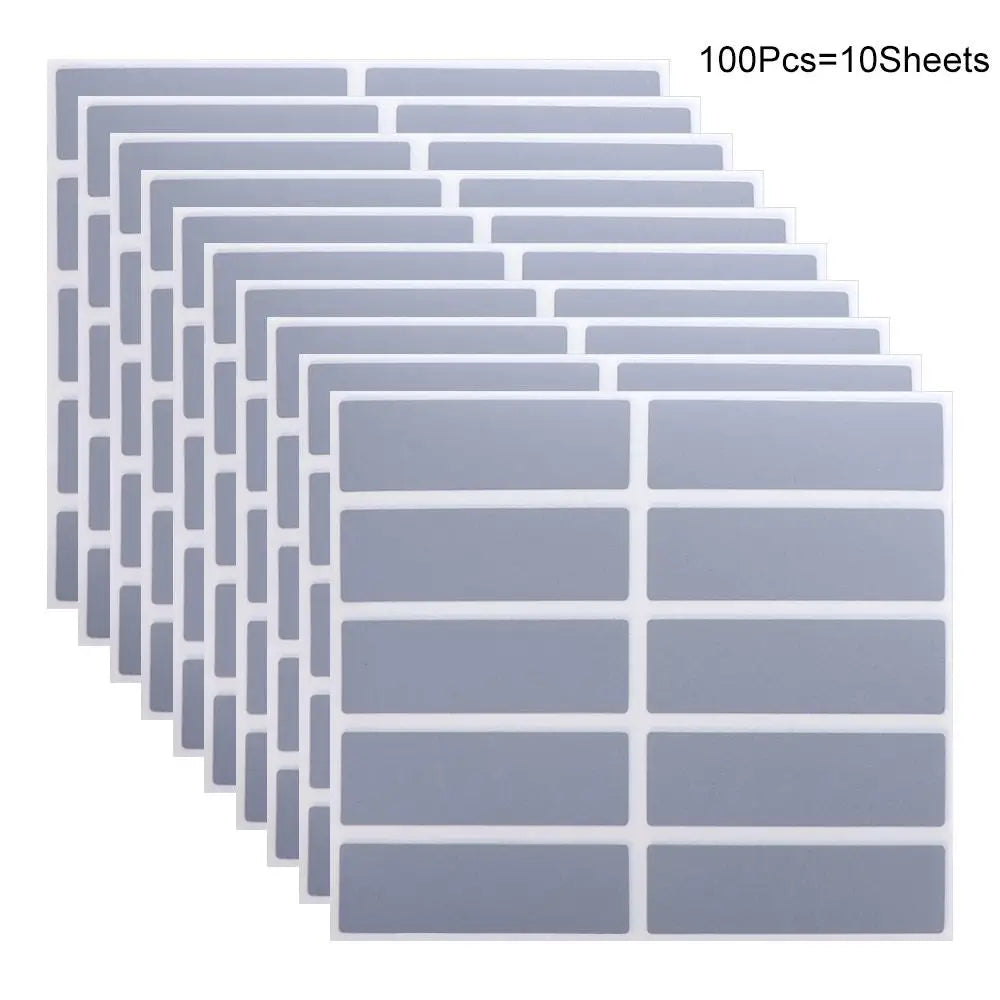A stack of square, translucent gray scratch-off sticker sheets arranged in rows and columns.