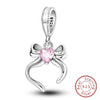 A sterling silver heart charm bead with a pink gemstone and a bow design.