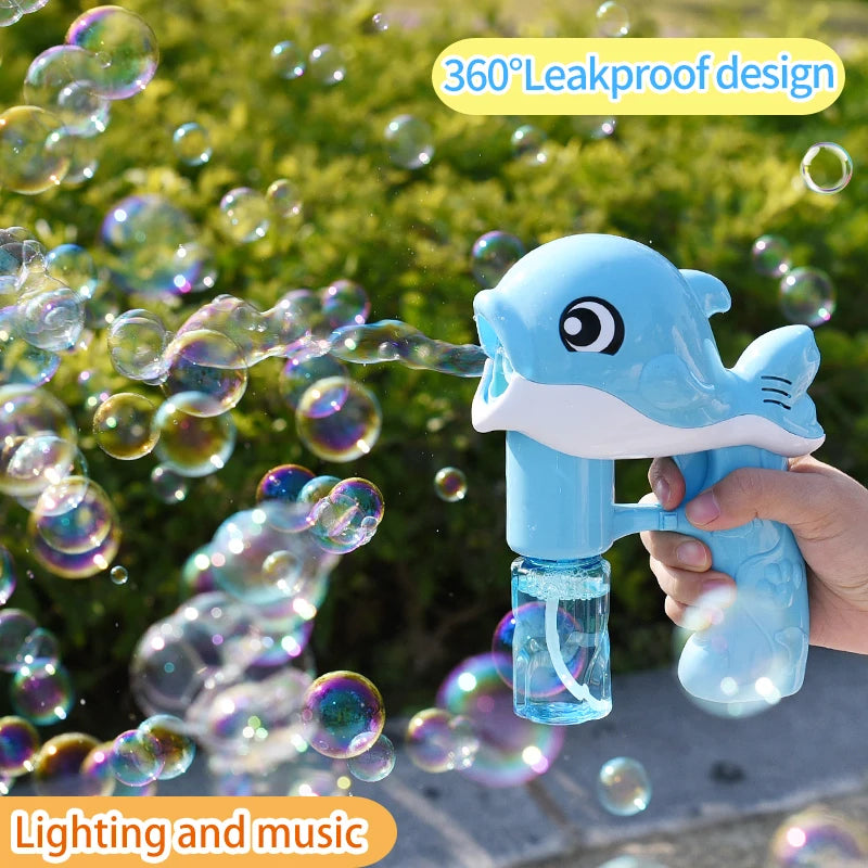 A hand is holding a blue whale bubble gun that is blowing bubbles in an outdoor setting.