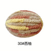 A ball of chunky chenille yarn in shades of pink, yellow, and beige.
