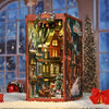 A wooden book nook kit featuring a detailed Christmas street corner miniature model with lights and seasonal decorations.