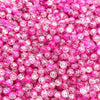 Close-up of small, round pink and clear crackle glass beads for jewelry making