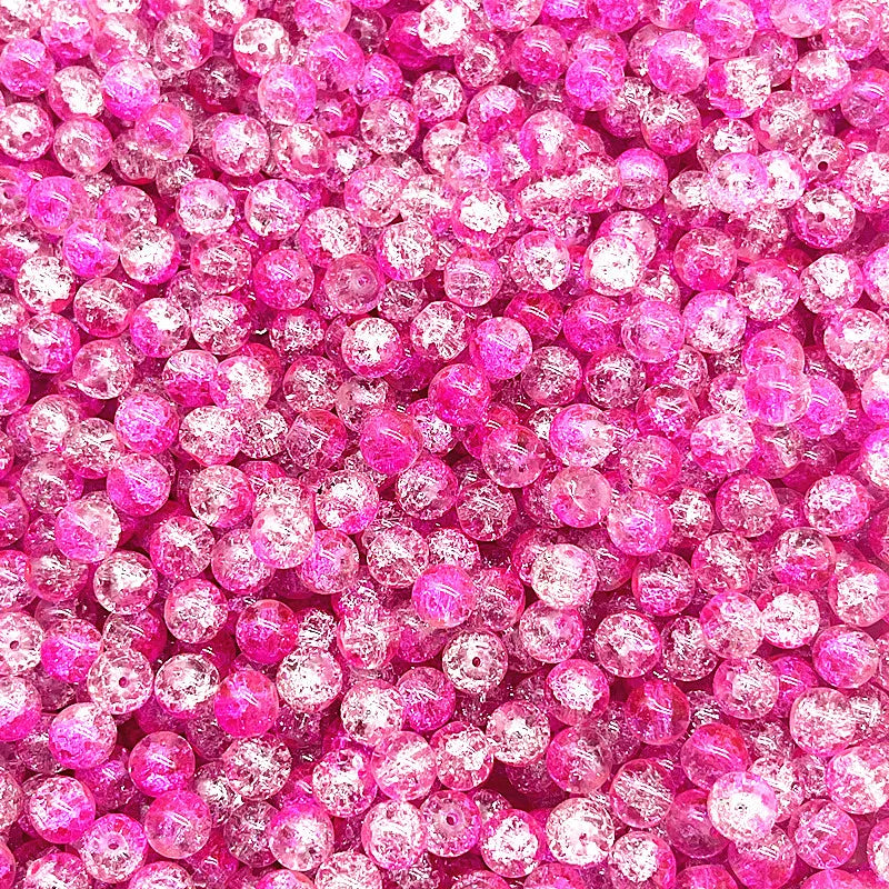 Close-up of small, round pink and clear crackle glass beads for jewelry making