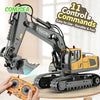 A remote control construction excavator truck with a yellow cab and black body is shown being operated by a hand.