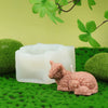 A silicone candle mold set featuring a pink highland cow design resting on green moss.