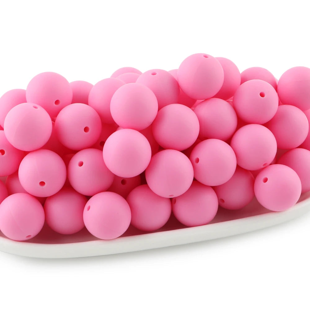 A pile of bright pink round silicone beads for jewelry making and DIY crafts.
