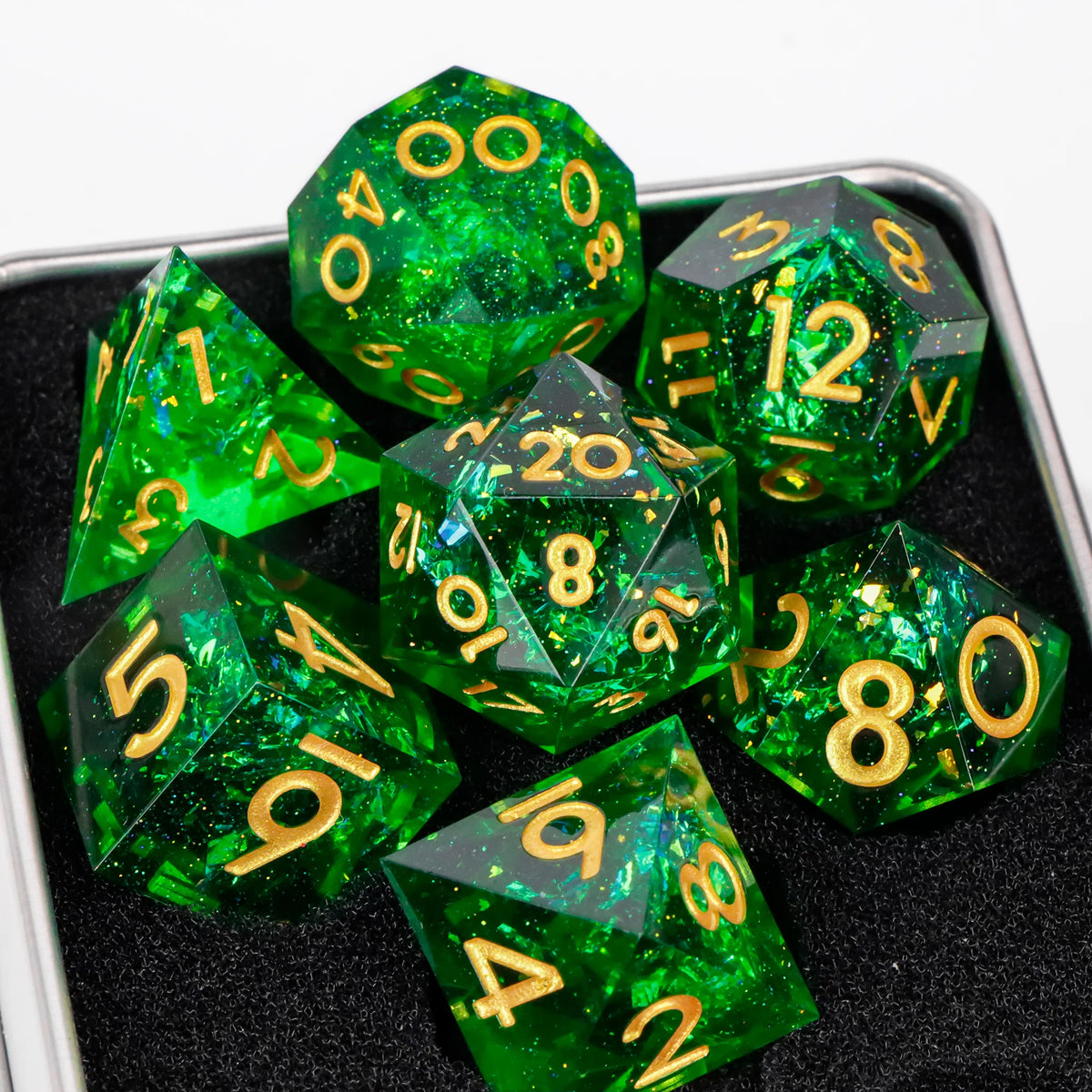 A collection of green resin dice, including d10s and d12s, displayed in a dark container.