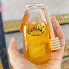A hand holds a glass bottle filled with yellow liquid and a white straw, labeled Chibok drink cup toy.