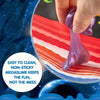 A hand is squeezing a purple, stretchy non-sticky slime ball on a red surface.