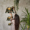 A woman is interacting with a large wooden jigsaw puzzle depicting various animals, including bears and other wildlife, hangi