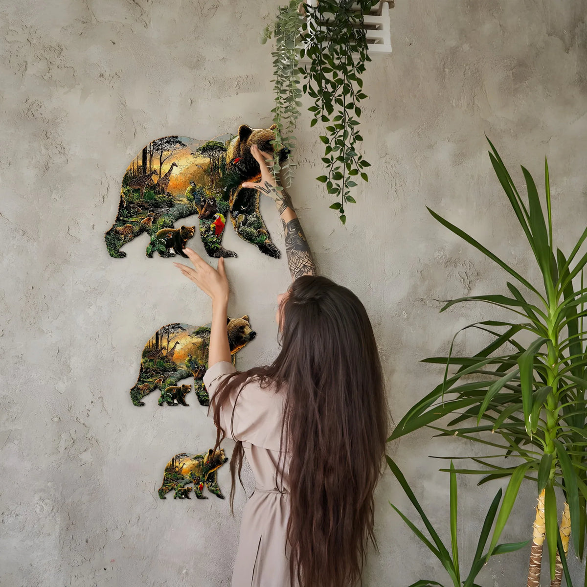 A woman is interacting with a large wooden jigsaw puzzle depicting various animals, including bears and other wildlife, hangi