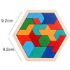 A wooden tangram puzzle board with colorful geometric shapes arranged in a hexagonal frame.