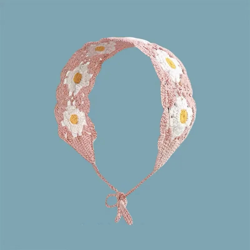 A pink strawberry crochet headband with a wide elastic band and white floral embroidery.