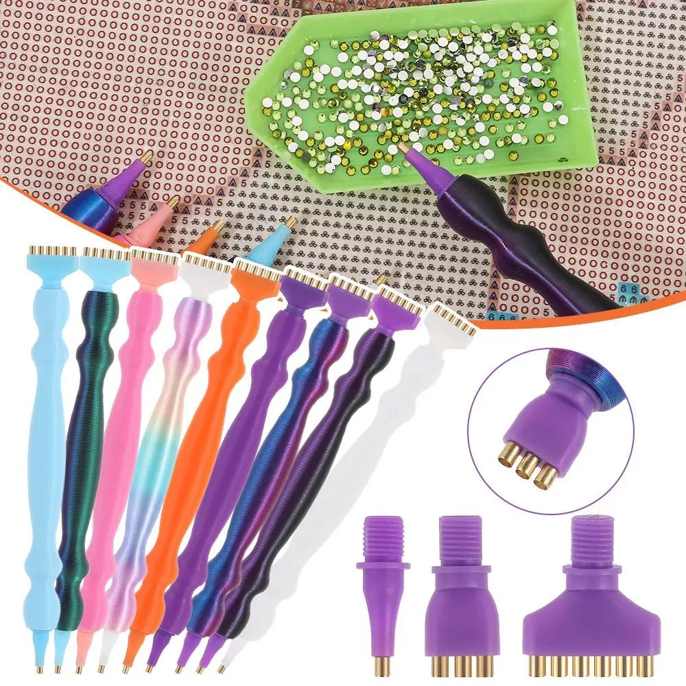 A collection of precision diamond painting pens and replacement tips in various colors are displayed on a textured background